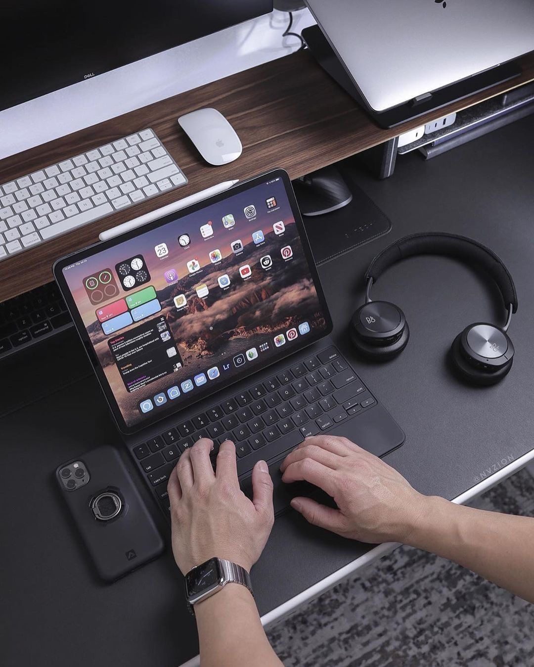 Escritorio de trabajo con iPad y Magic Keyboard, Magic Mouse, auriculares y funda para iPhone