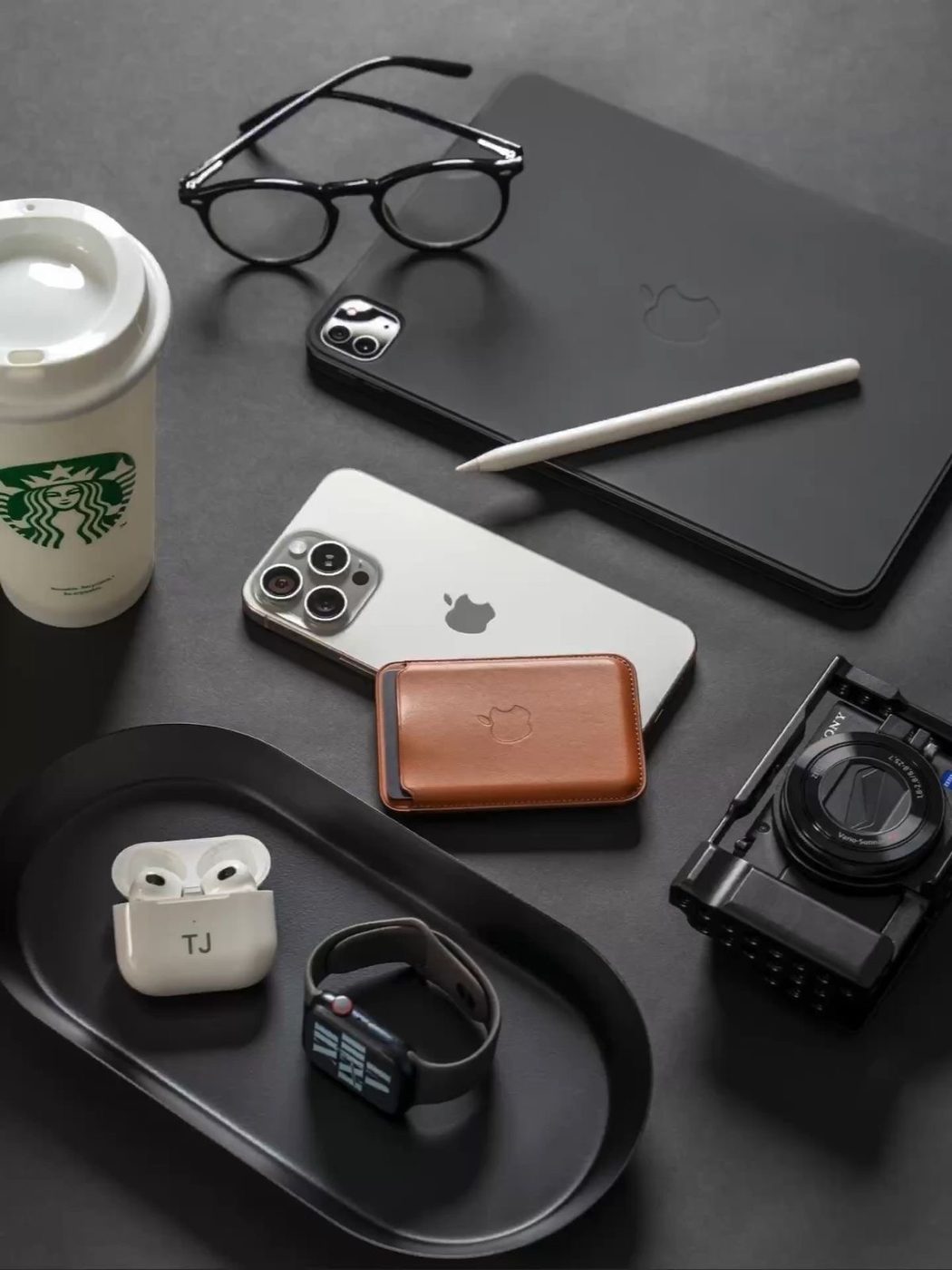 AirPods, Apple Watch y billetera MagSafe sobre una bandeja negra